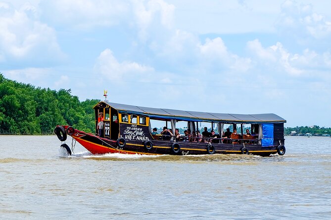 Small-Group Mekong Delta Day Trip: Boat Ride, Cottages & Pagoda - Boat hops and canal scenery, including hand-rowed time